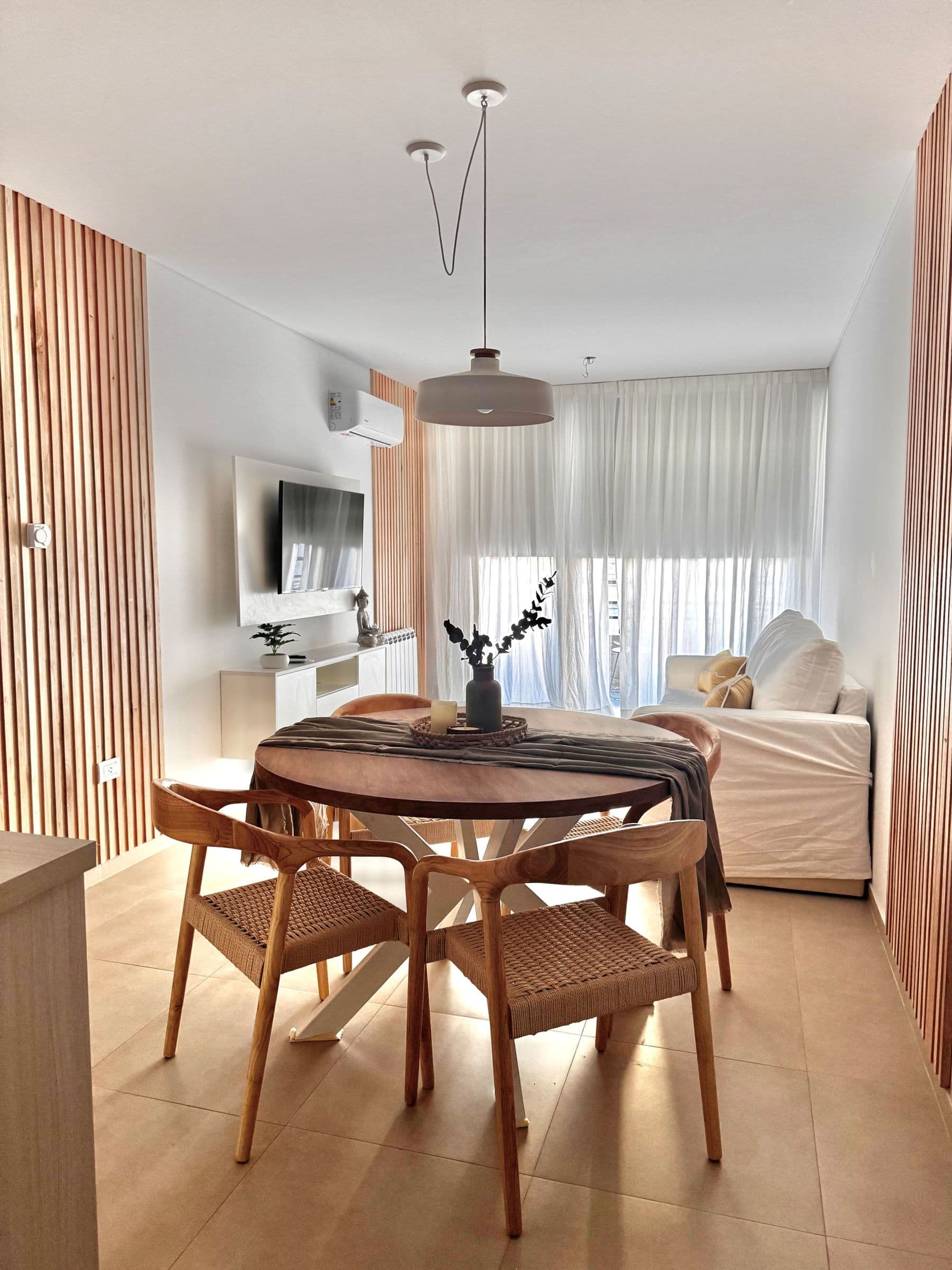 Comedor redondo de madera con sillas junto al living de Palazzo Tiberio 1