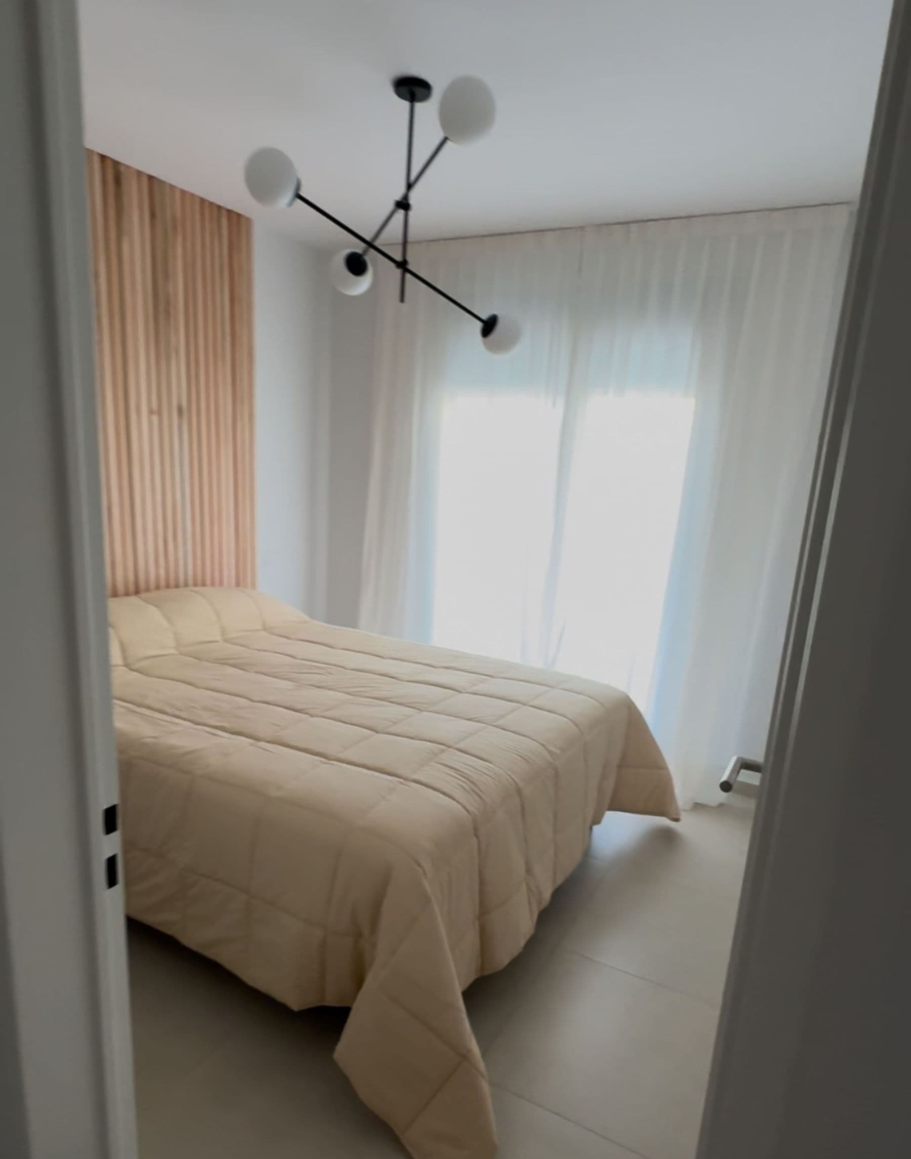 Dormitorio con cama doble y cortinas claras en Palazzo Tiberio 1
