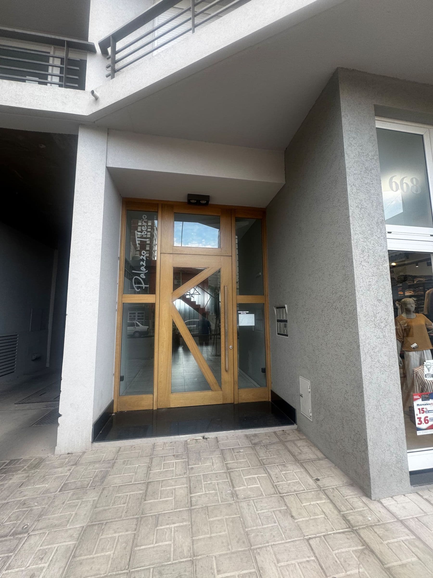 Entrada del edificio con puerta de madera y vidrio