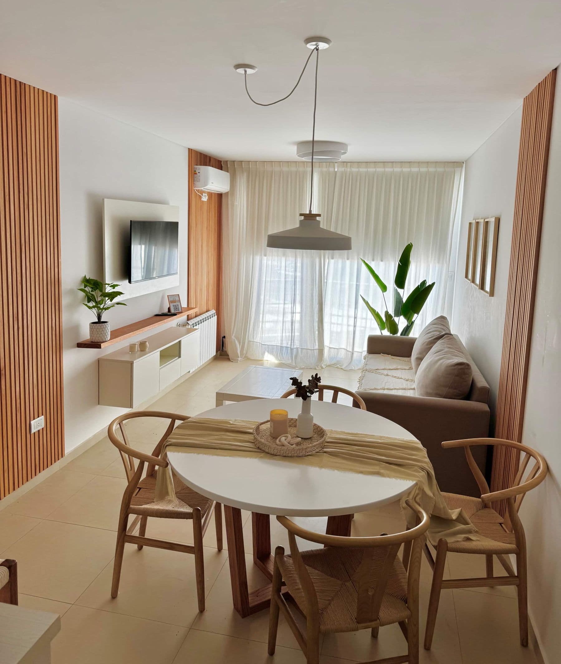 Living-comedor de Palazzo Tiberio 3 con mesa redonda blanca y sillas de madera