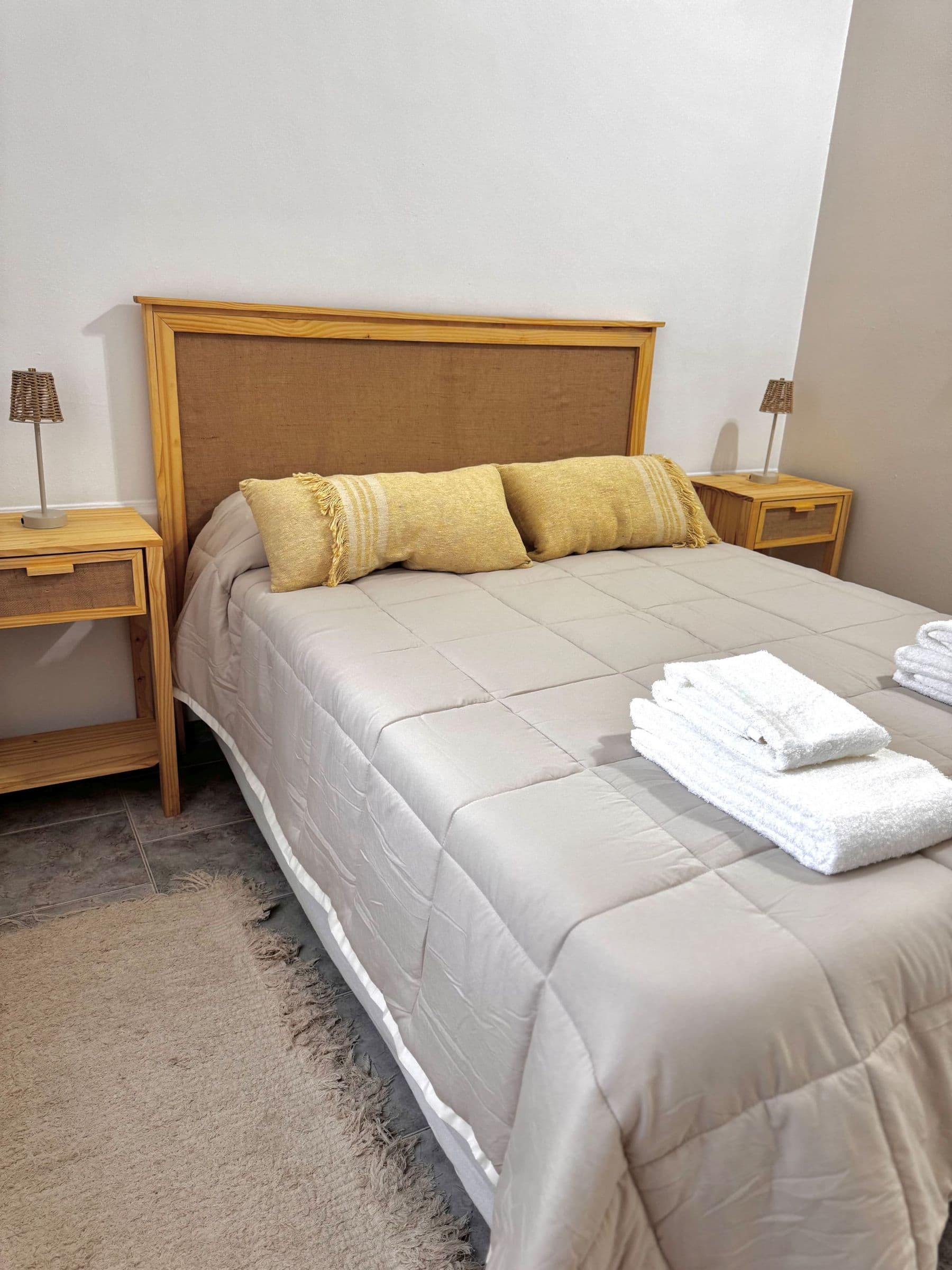Dormitorio principal con cama doble y respaldo de mimbre