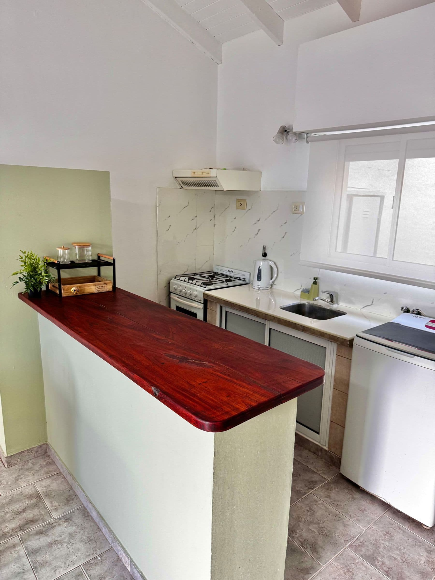 Cocina con barra de madera, anafe y heladera